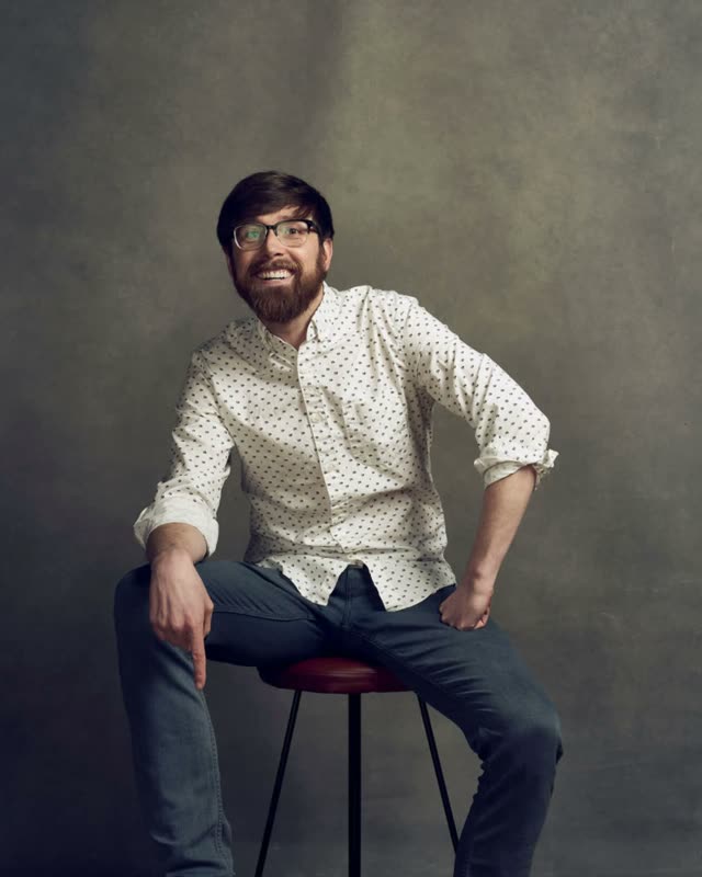 Colton Mulligan headshot: On the stool, laughing