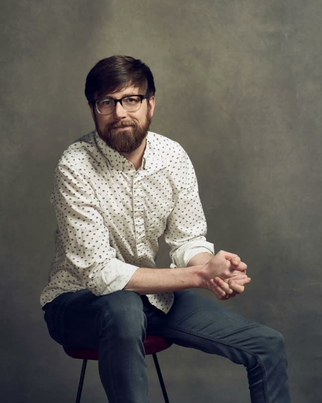 Colton Mulligan headshot: On the stool, white shirt