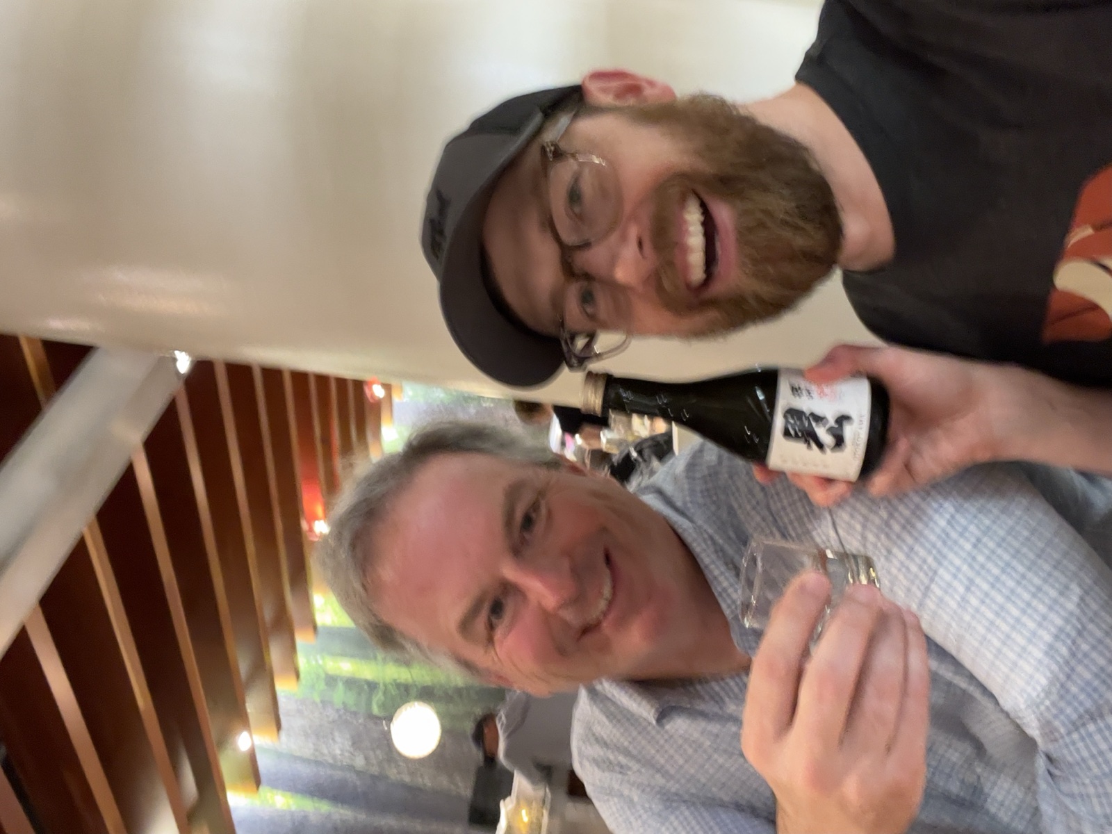 Colton and Richard Moscardelli laughing with a bottle, June 2025